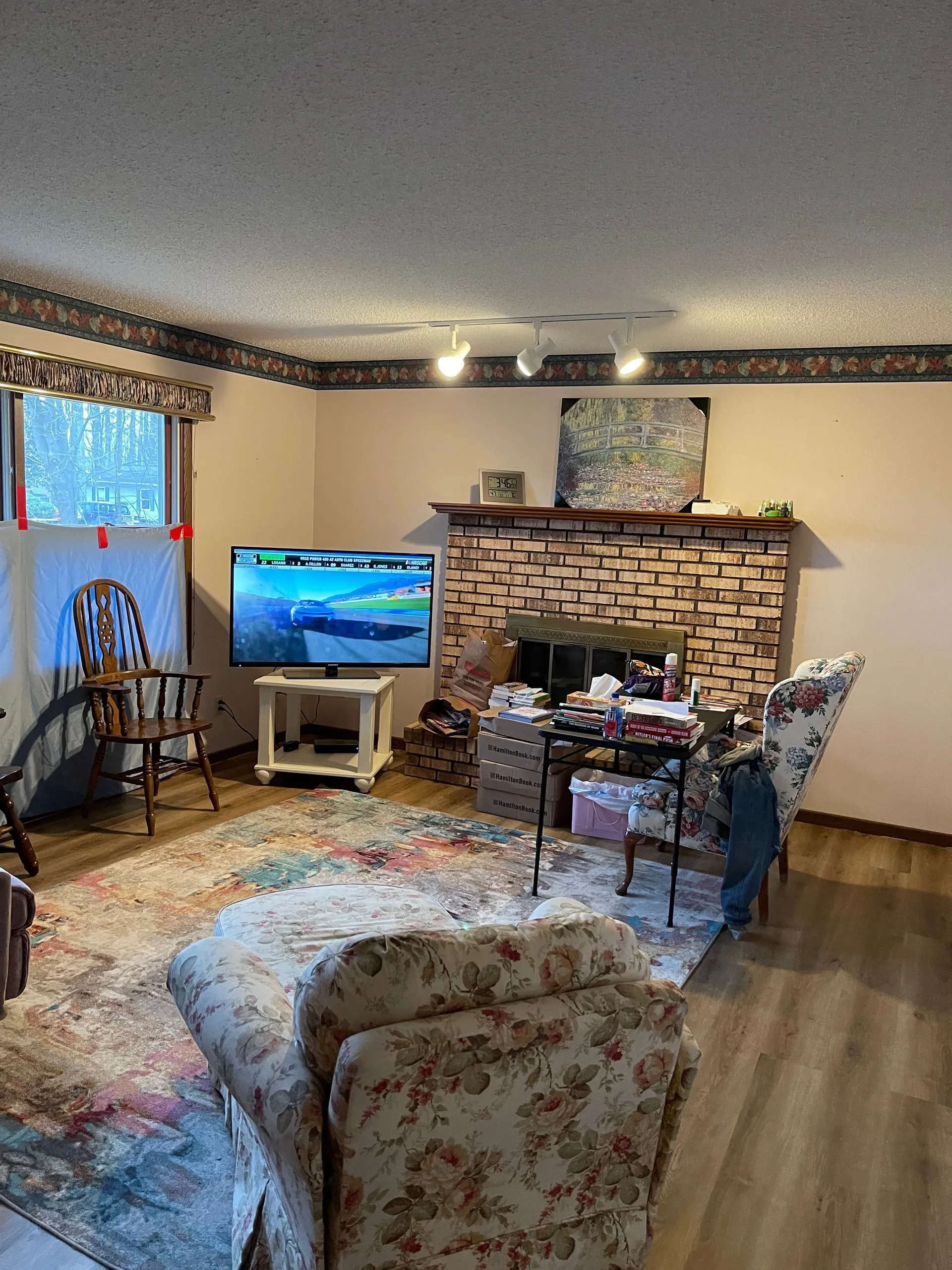 An image of a clean living room with sofa chairs and a fireplace