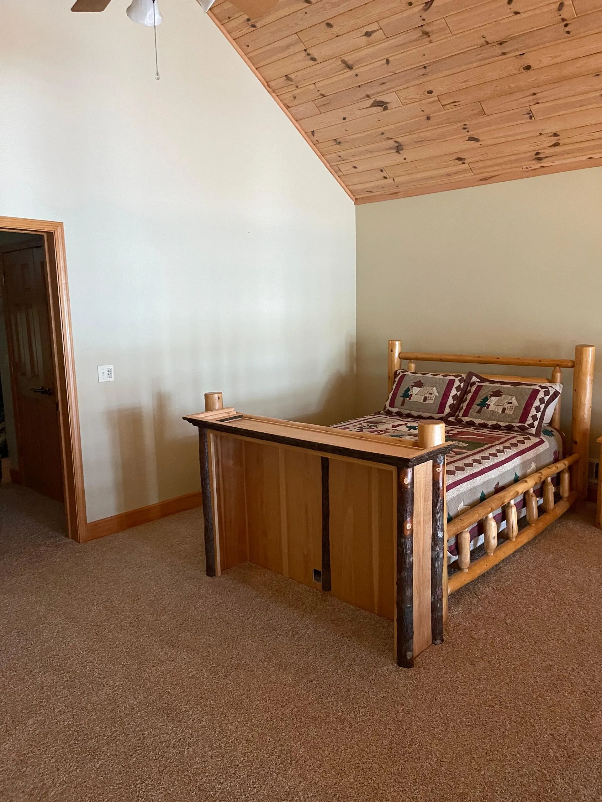 An image of a clean room with a wooden bed frame