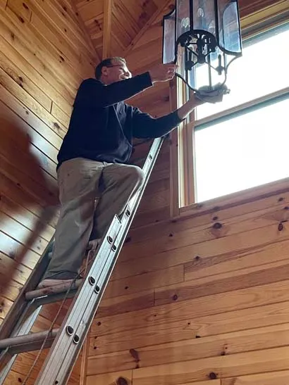 An image of a handy man doing some repair or installing lights