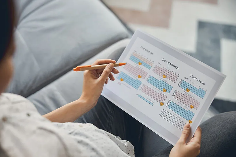 woman ticking checkbox on paper calendar
